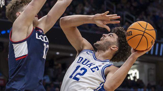 Connecticut center Eric Reibe (12) defends Duke forward Cameron Boozer (12) in the first half on Sunday, March 29, 2026, in the NCAA East Regional Championship, at Capital One Arena in Washington, D.C.