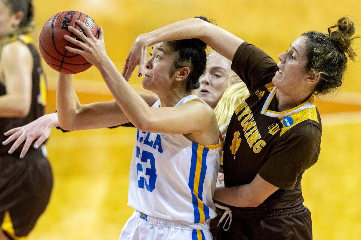 UCLA guard Natalie Chou (23) scores under Wyoming guard Alba Sanchez Ramos during the second half of a college basketball game in the first round of the women’s NCAA tournament at the Frank Erwin Center in Austin, Texas, Monday, March 22, 2021. 