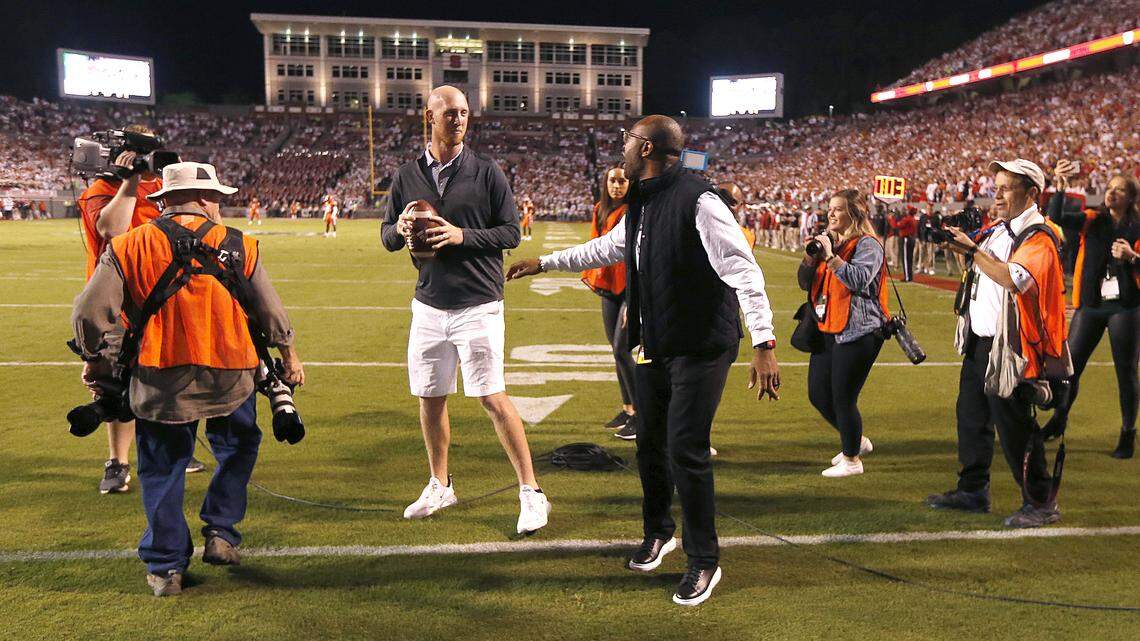 Former N.C. State receiver Torry Holt talks to former quarterback Mike Glennon about the best pass during a ceremony honoring Holt’s induction into the College Football Hall of Fame during the first half of N.C. State’s game against Syracuse at Carter-Finley Stadium in Raleigh, N.C., Thursday, Oct. 10, 2019.