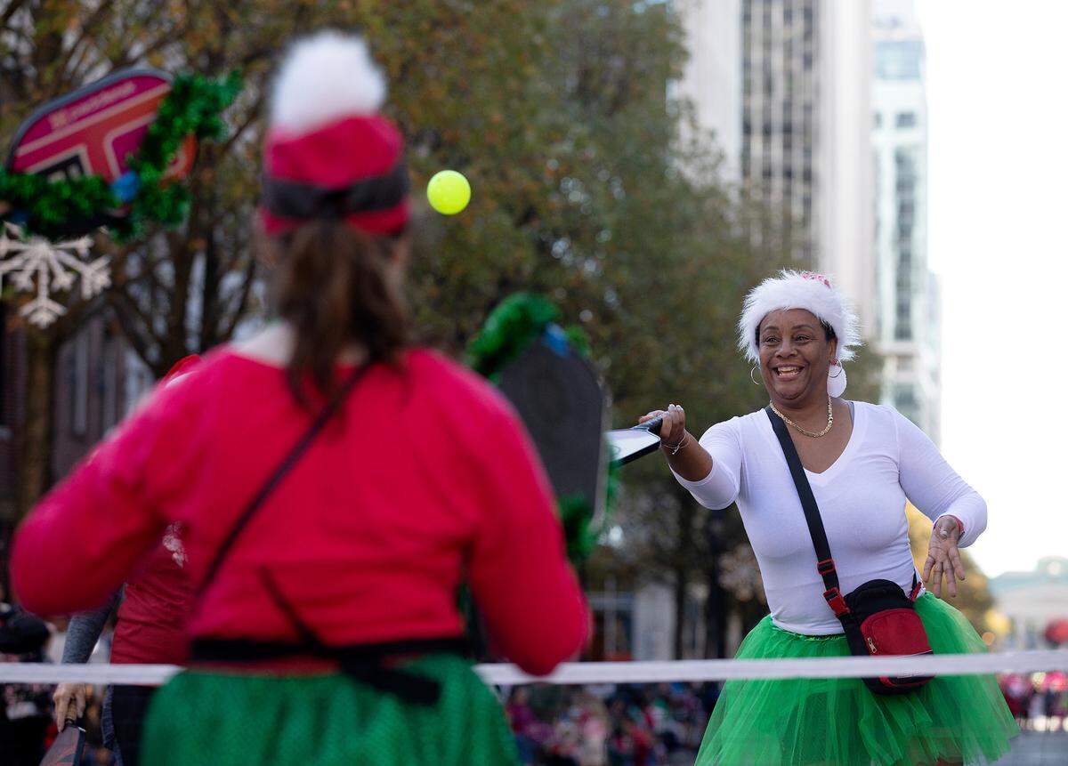 Ellen Nathan, right, plays pickleball on Fayetteville Street with the Black Knights Pickleball Club during the Raleigh Christmas Parade on Saturday, Nov. 18, 2023.
