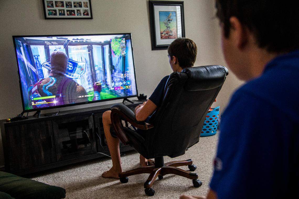 Chase Carson watches as Jackson Pittman, both 15, play Fortnite on a Playstation 4 gaming console at a friend’s home in Raleigh Wednesday, Sept. 23, 2020.