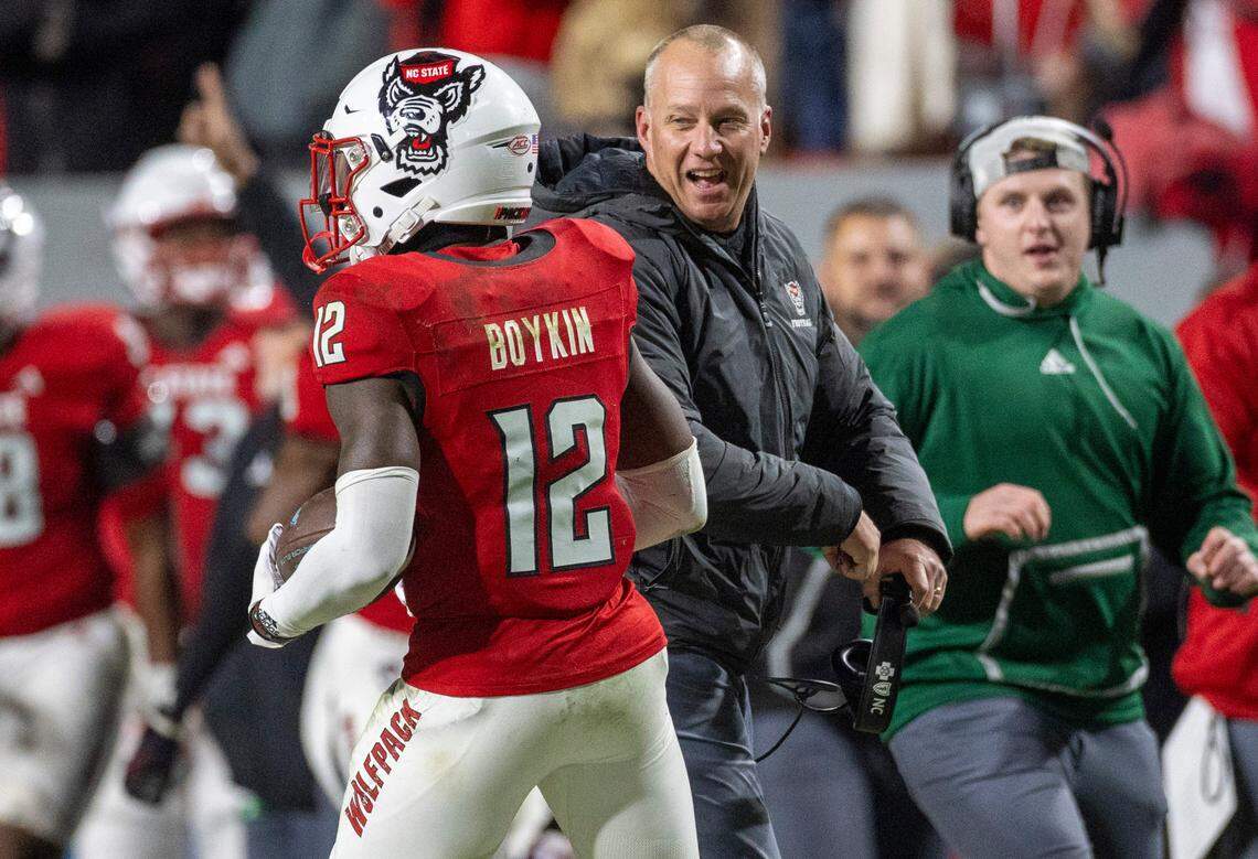 N.C. State coach Dave Doeren chest bumps Devan Boykin (12) after he intercepted a Drake Maye pass to secure the Wolfpack’s 39-20 over North Carolina victory on Saturday, November 25, 2023 at Carter-Finley Stadium in Raleigh, N.C.