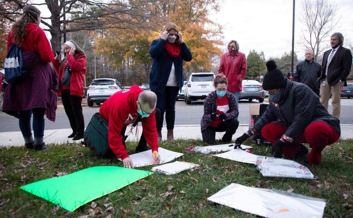 Some members of NCAE make signs before a rally outside the Wake County School Board meeting in Cary, N.C. on Tuesday, Dec. 7, 2021.
