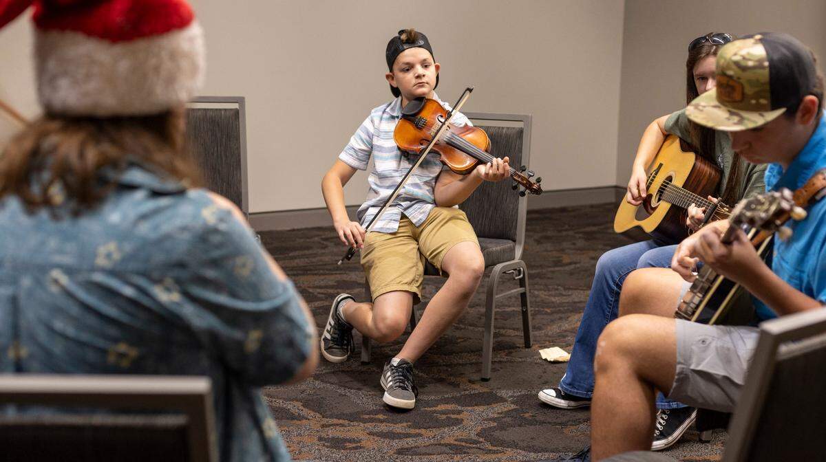From left, Finn McGuinness of Islesford, Maine, Malachi Ellenburg, Alyssa White and Elijah Ellenburg of Pickens, S.C. play together in the Youth Room at the Raleigh Convention Center during the IBMA World of Bluegrass 2023 on Wednesday, September 27, 2023 in Raleigh, N.C.