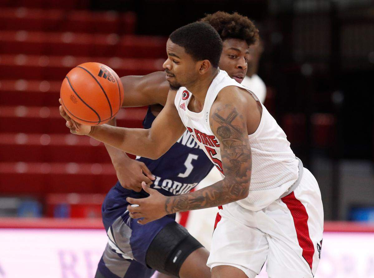 N.C. State’s Thomas Allen (5) steals the ball from North Florida’s Dorian James (5) during the first half of N.C. State’s game against North Florida in the Mako Medical Wolfpack Invitational at Reynolds Coliseum in Raleigh, N.C., Friday, Nov. 27, 2020.