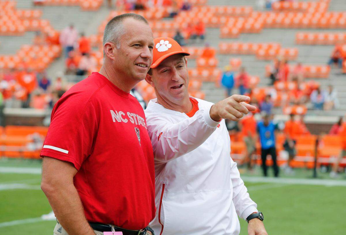 N.C. State head coach Dave Doeren talks with Clemson head coach Dabo Swinney before N.C. State’s game against Clemson at Memorial Stadium in Clemson, S.C., Saturday, Oct. 20, 2018.