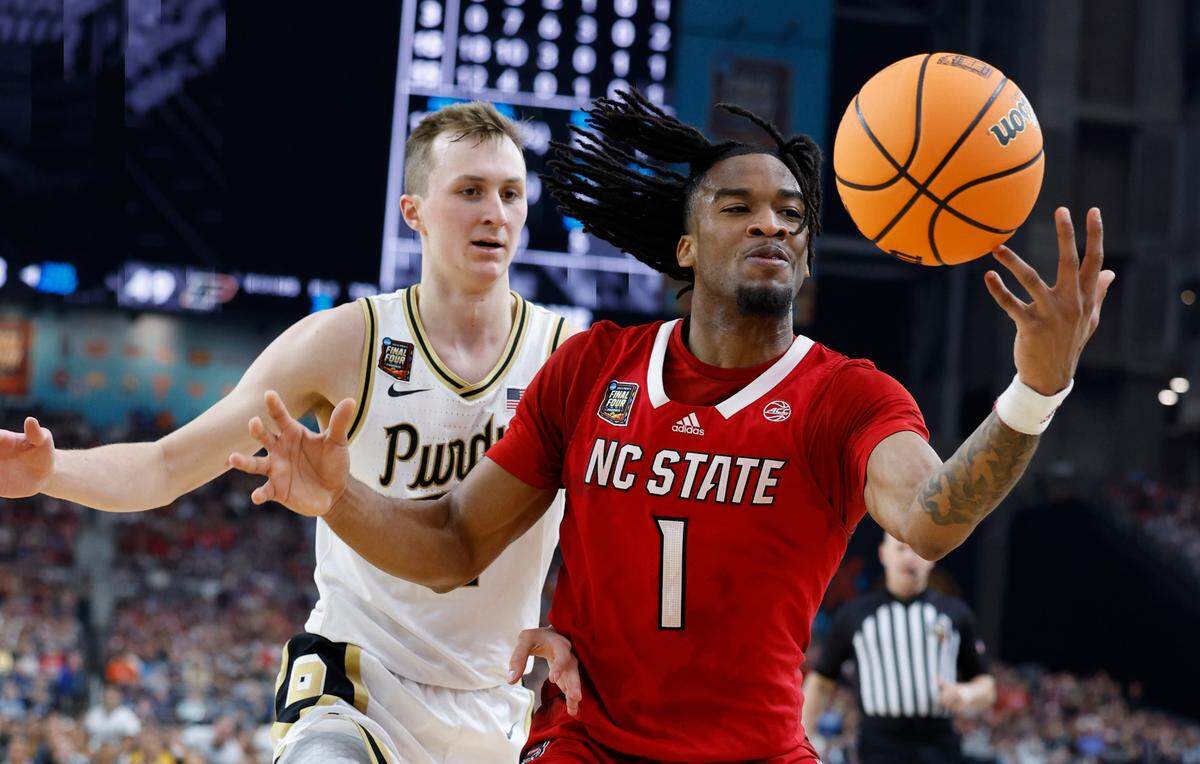 NC State’s Jayden Taylor (1) tries to get possession of the ball as Purdue’s Fletcher Loyer defends in second half action of their Final Four game, Saturday, April 6, 2024.