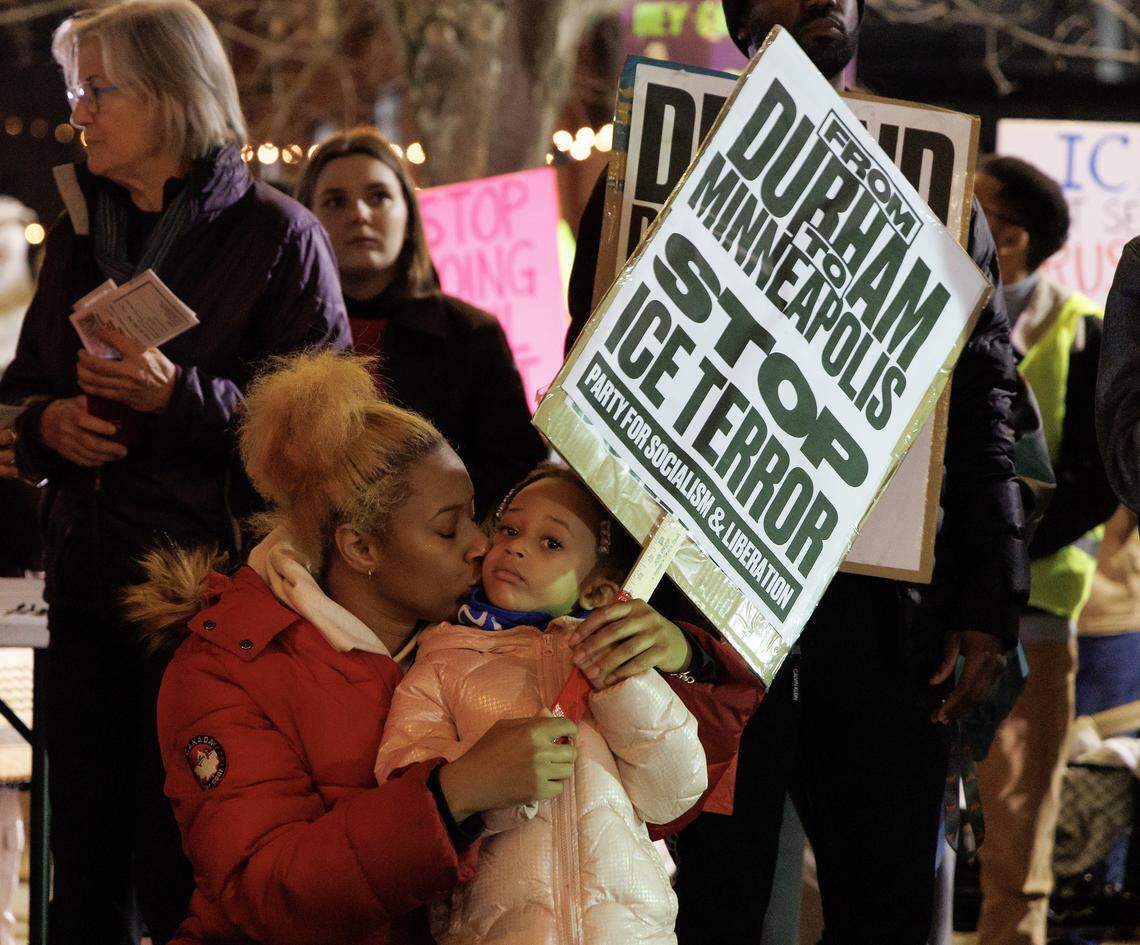 Demia Tucker kisses her daughter, Lia Tucker-Owens, 3, as a crowd gathers prior to a protest in downtown Durham on Thursday, Jan. 8, 2026, held in response to Wednesday’s fatal shooting of Renee Nicole Good by a federal immigration agent in Minneapolis.