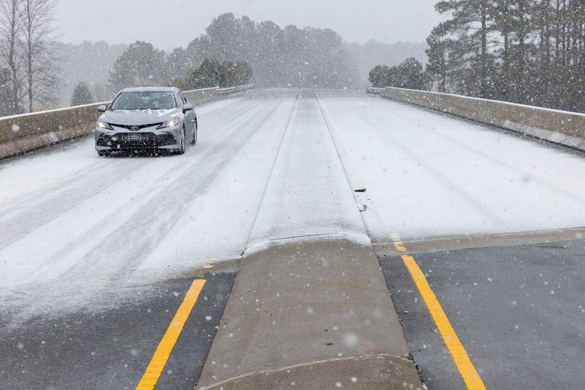 Snow begins stick on a bridge over US 64 as a winter storm moves through the area on Wednesday, February 19, 2025 in Pittsboro, N.C.
