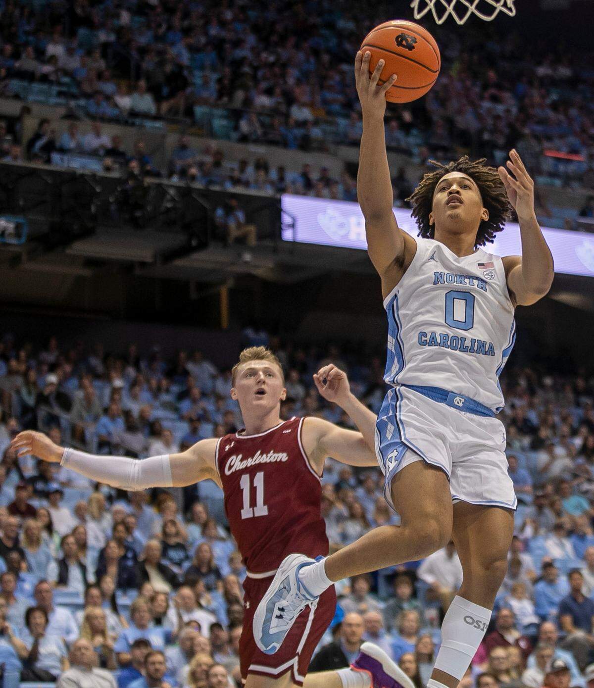 North Carolina’s Seth Trimble (0) breaks to the basket against College of Charleston’s Ryan Larson (11) during the first half on Friday, November 11, 2022 at the Smith Center in Chapel Hill, N.C.
