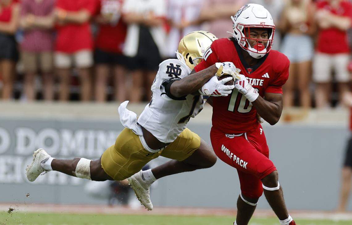N.C. State wide receiver KC Concepcion (10) tries to break free from Notre Dame safety Thomas Harper (13) during the second half of Notre Dame’s 45-24 victory over N.C. State at Carter-Finley Stadium in Raleigh, N.C., Saturday, Sept. 9, 2023.