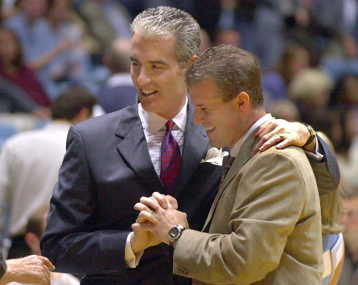 UNC coach Matt Doherty (left) and Tulsa head coach Buzz Peterson (right), talk before the start of the UNC-Tulsa game in 2000.  Both were teammates on the Tar Heels 1982 National Championship team and are in their first year as head coaches at their schools. 