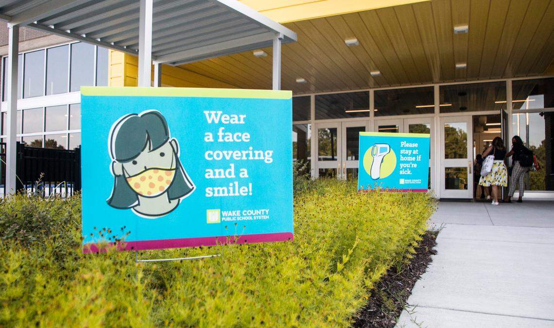 Signs encouraging mask wearing and other pandemic precautions are seen outside of Conn Elementary School in Raleigh, N.C. before students arrive for the first day of school on Monday, Aug. 23, 2021.
