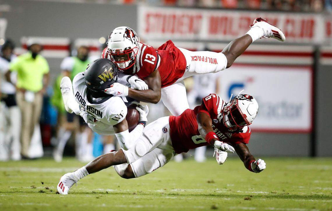 Wake Forest wide receiver Jaquarii Roberson (5) makes the reception as N.C. State’s Tyler Baker-Williams (13) and Jakeen Harris (6) defend during the first half of N.C. State’s game against Wake Forest at Carter-Finley Stadium in Raleigh, N.C, Saturday, Sept. 19, 2020.