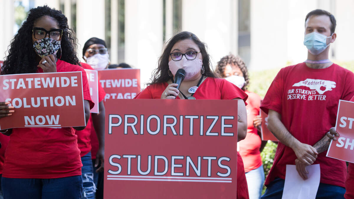 Wake County NCAE chapter president Kristin Beller, middle, speaks during a press conference on bus driver shortages outside the General Assembly in Raleigh, N.C. on Friday, Sept. 10, 2021.