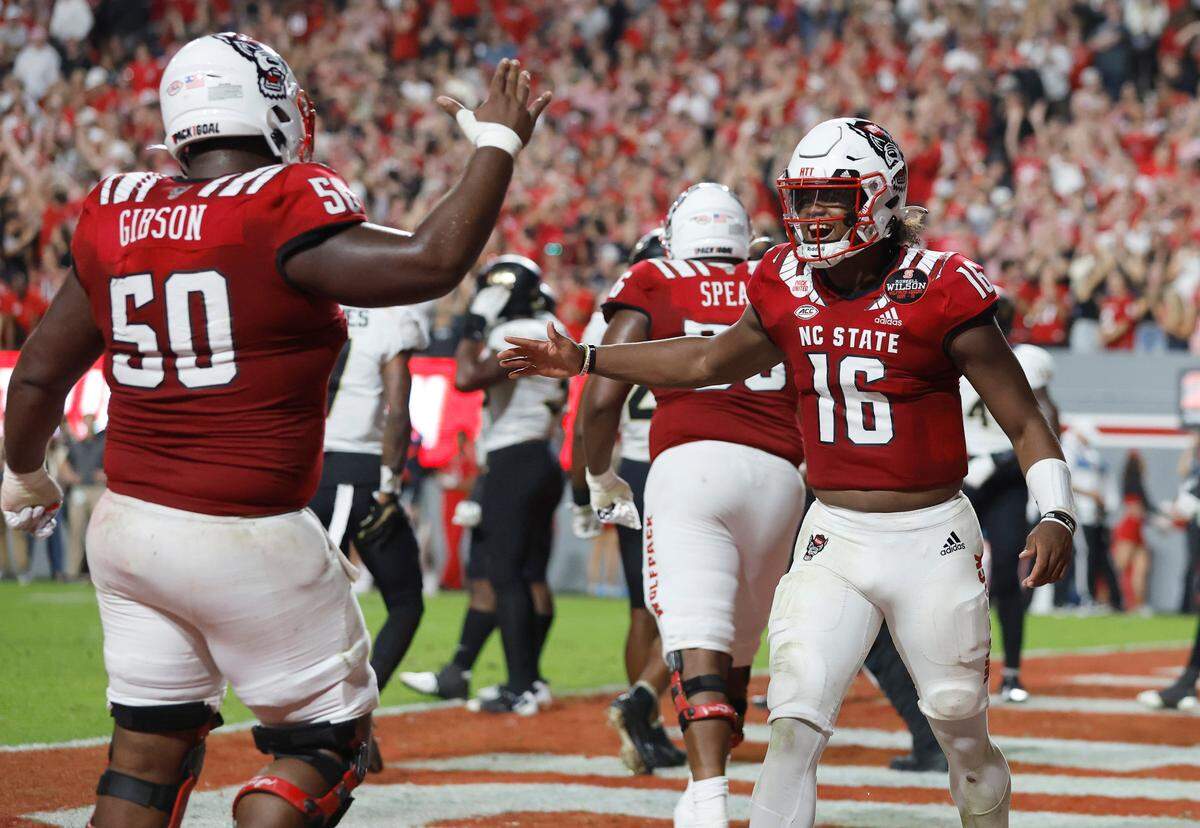 N.C. State quarterback MJ Morris (16) celebrates with Grant Gibson (50) after throwing a 1-yard touchdown to wide receiver Darryl Jones during the second half of N.C. State’s 30-21 victory over Wake Forest at Carter-Finley Stadium in Raleigh, N.C., Saturday, Nov. 5, 2022.