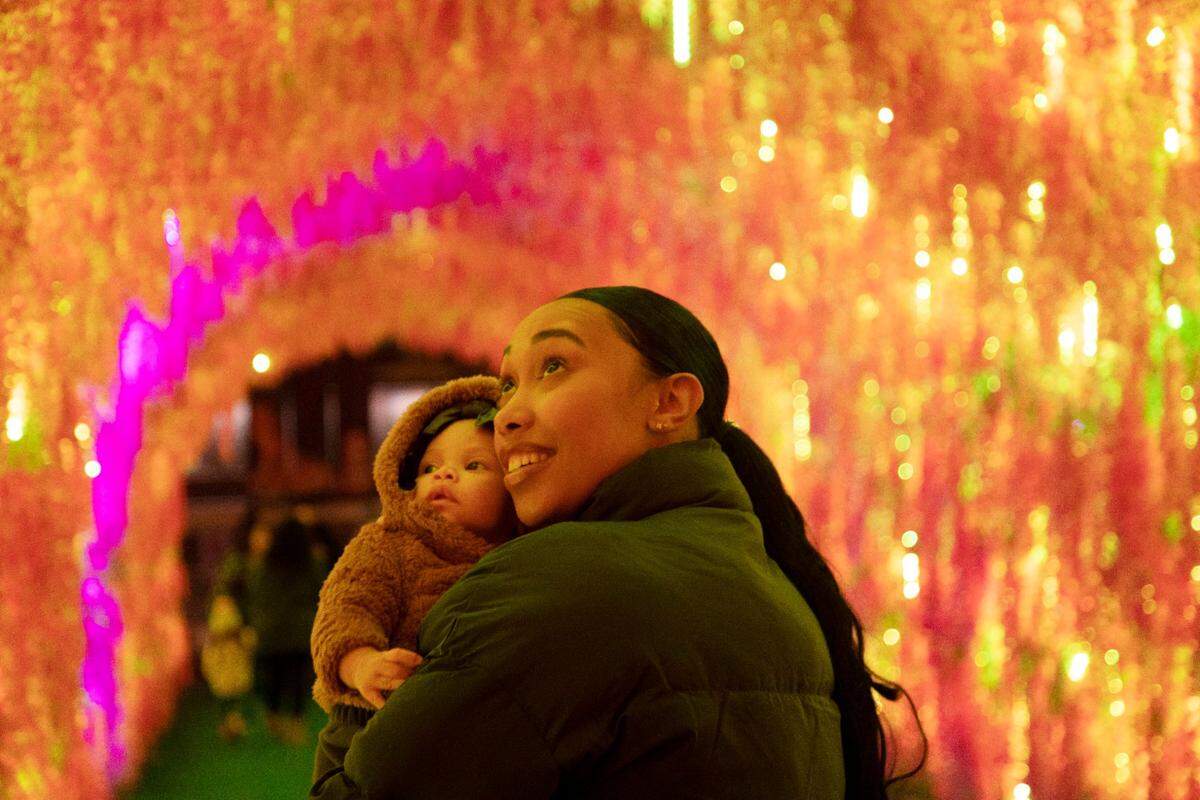 Deiara Frye, right, holds her four-month-old Samaiha Frye as they visit the Chinese Lantern Festival at Koka Booth Amphitheatre in Cary on Wednesday evening, Dec. 22, 2021. The festival, now in its fifth year, features over 35 displays and will be open daily through Jan. 9.