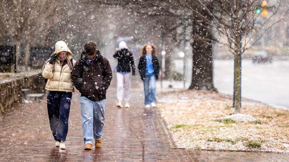 Pedestrians brave the freezing temperature as snow begins to fall at UNC-Chapel Hill on Wednesday, Feb. 19, 2024.