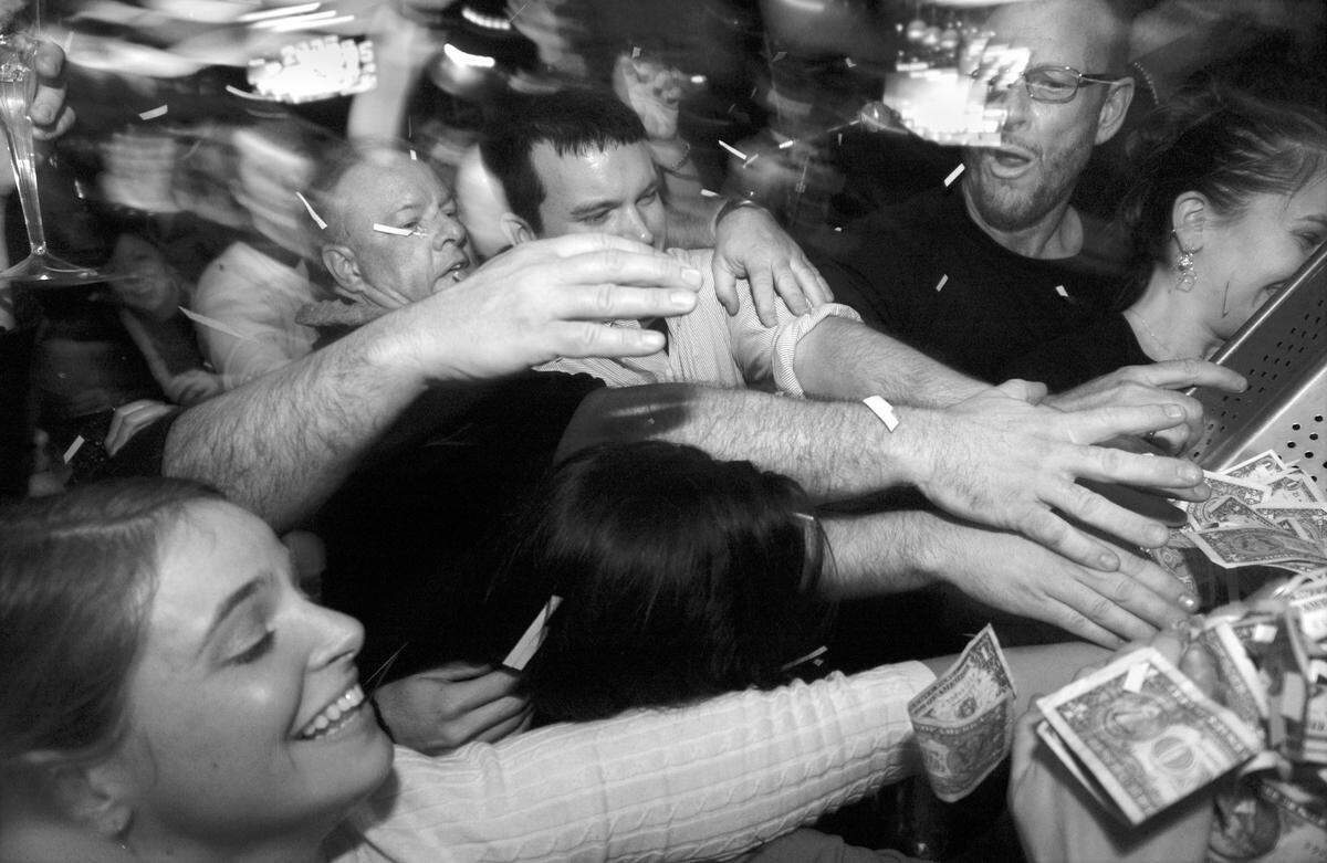 “My guys tested this, (but) it didn’t work,” said Rob Zinbar, owner of Crowley’s Restaurant and Bar at Stonehenge in North Raleigh. He planned to drop 500 one dollar bills onto the dance floor at midnight on New Year’s Eve blowing the money in the air from the stage using a leaf-blower. But, as his staff struggled with the blower, the excited patrons stormed the stage and knocked the money on the floor, where about a dozen people crawled to claim the bills. “I had more, but someone ripped it from my hands,” laughed Maria Geremina , 21-year-old ECU student who collected $7. “I just want to let everybody start on the right foot and have a prosperous new year,” said Zinbar, who also celebrated the one-year anniversary of his business Saturday. (Staff photo / Takaaki Iwabu)