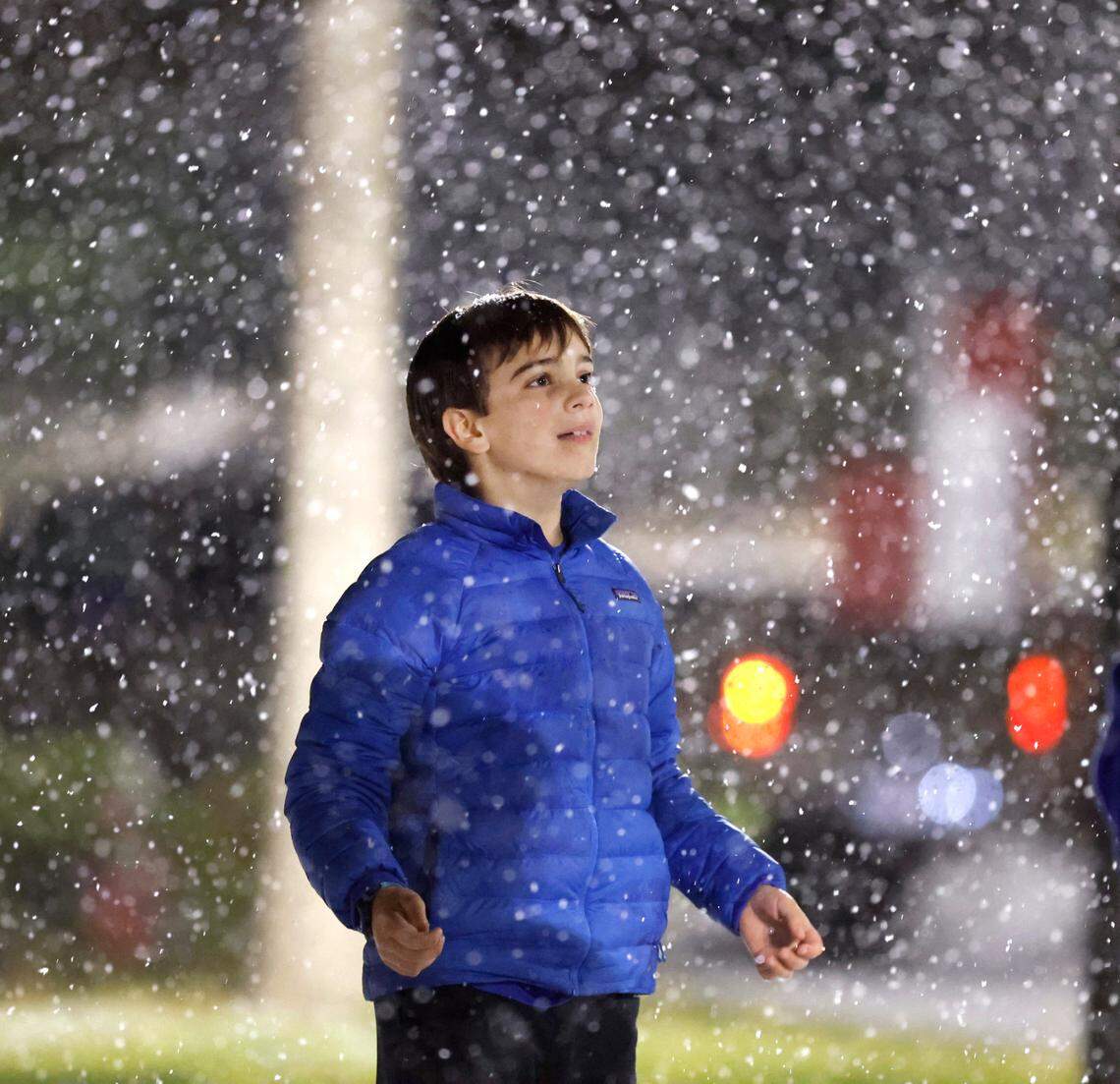 William Dowling, 11, of Raleigh, watches the snow come down outside Reynolds Coliseum in Raleigh, N.C., Friday, Jan. 10, 2025.