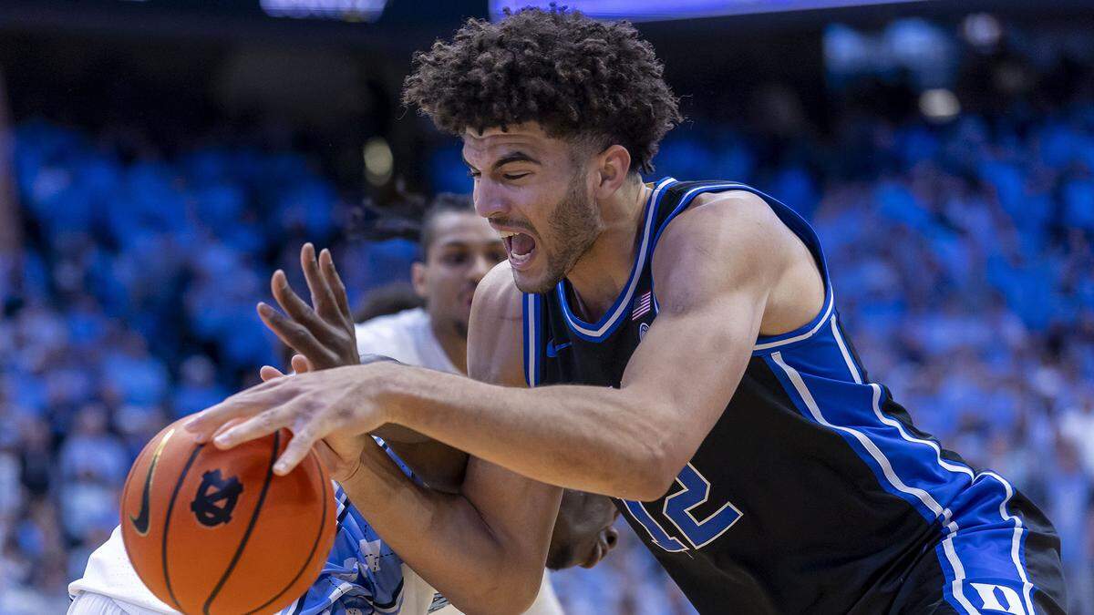 Duke forward Cameron Boozer (12) drives around North Carolina forward Caleb Wilson (8) in the first half on Saturday, February 7, 2026 at the Smith Center in Chapel Hill, N.C.  