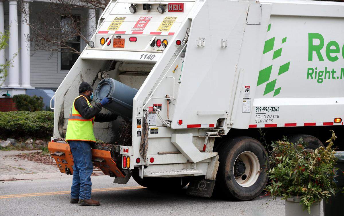A Raleigh sanitation works pick up yard waste in Raleigh, N.C. Thursday, March 26, 2020.