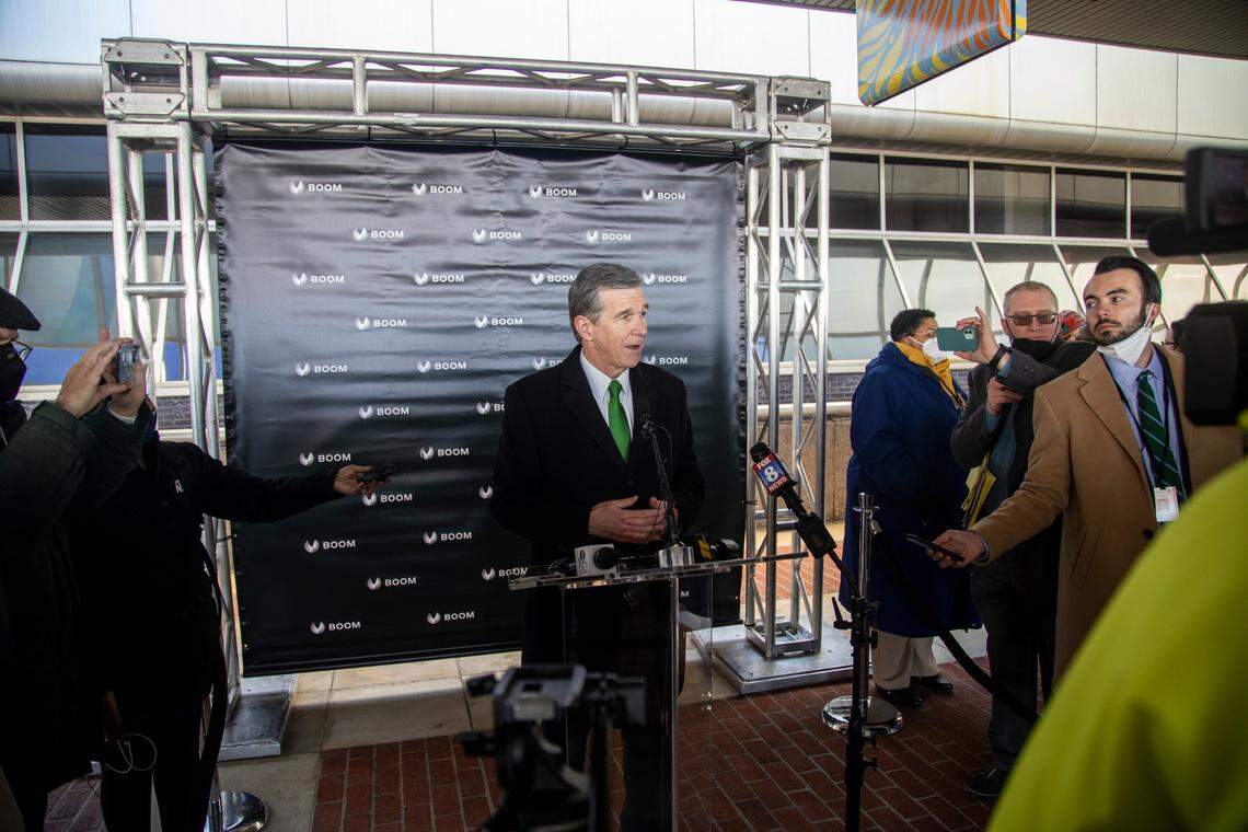 Gov. Roy Cooper speaks with reporters following a press conference Wednesday, Jan. 26, 2022 at Greensboro’s Piedmont Triad International announcing Boom Supersonic’s plans to build a $500 million “flagship” production facility at the airport that is expected to create more than 1,750 jobs.