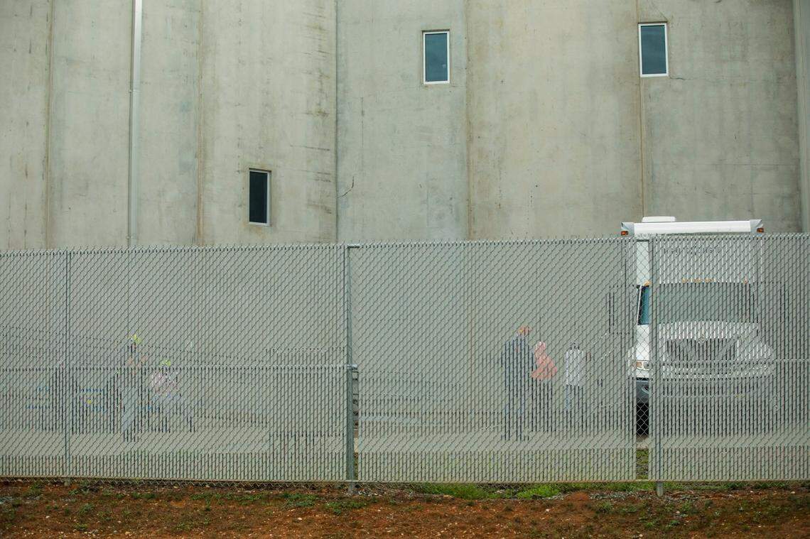 Workers at Mountaire Farms, a poultry processing plant, line up outside a truck displaying the logo of Examinetics, whose website advertises the service of onsite mobile health screenings, on Monday, Aug. 3, 2020, in Siler City, N.C.