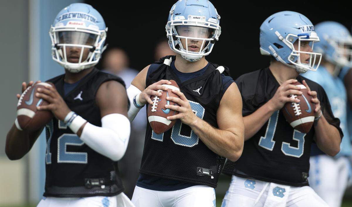 North Carolina quarterbacks, freshman Donovan Brewington (12), junior Jace Ruder (10) and freshman Vincent Amendola (13) work out during the Tar Heels’ first practice of the season on Friday, August 2, 2019 at the Football Practice Complex in Chapel Hill, N.C.