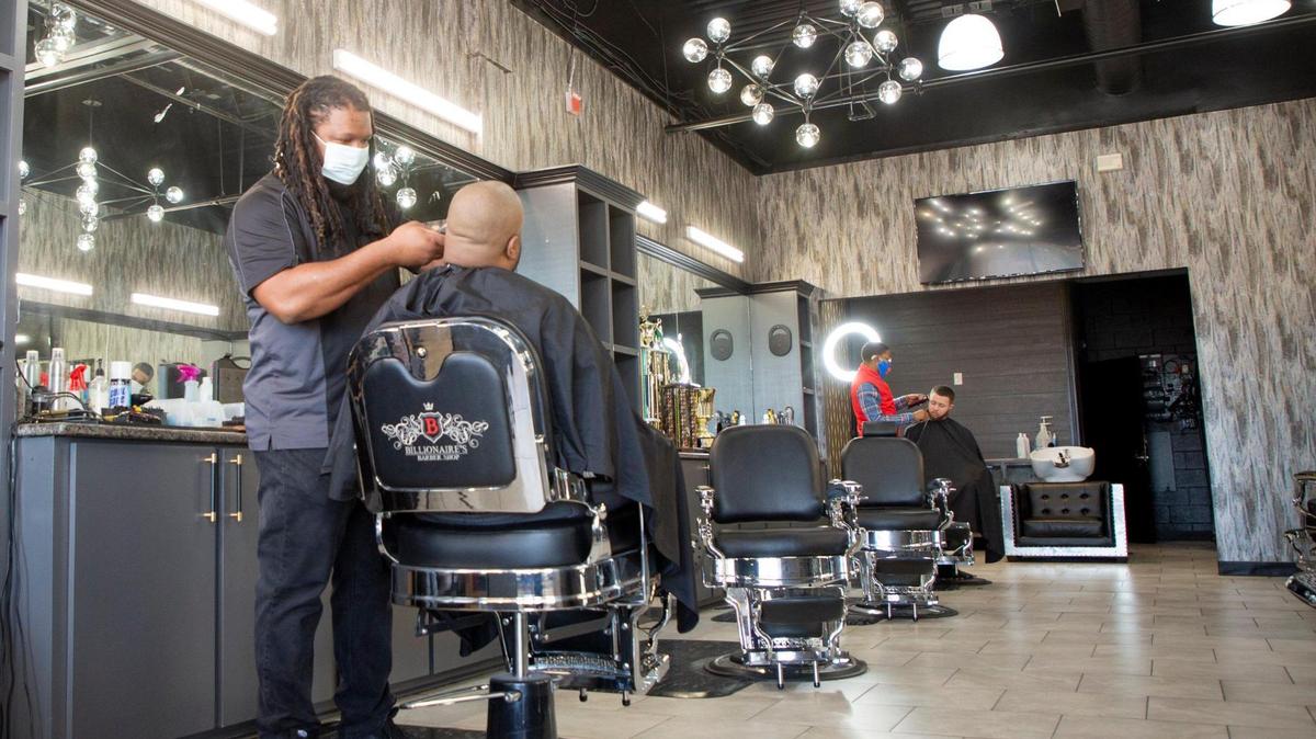 Chris Short, owner of Billionaire’s Barber Shop in Cary, trims a customer’s hair in February 2021. Short said business dropped by about half during the pandemic. He was in the process of applying for a Paycheck Protection Program loan to help with payroll expenses.
