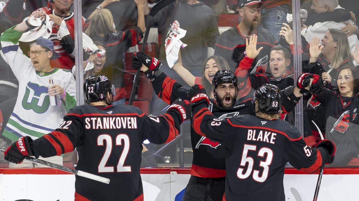 Carolina Hurricanes defenseman Shayne Gostisbehere (4) celebrates with teammates Logan Stankoven (22) and Jackson Blake (53), after scoring to tie Las Vegas 4-4 in the third period of Game 1 in the Stanley Cup Finals, on Tuesday, June 2, 2026 at Lenovo Center in Raleigh, N.C.