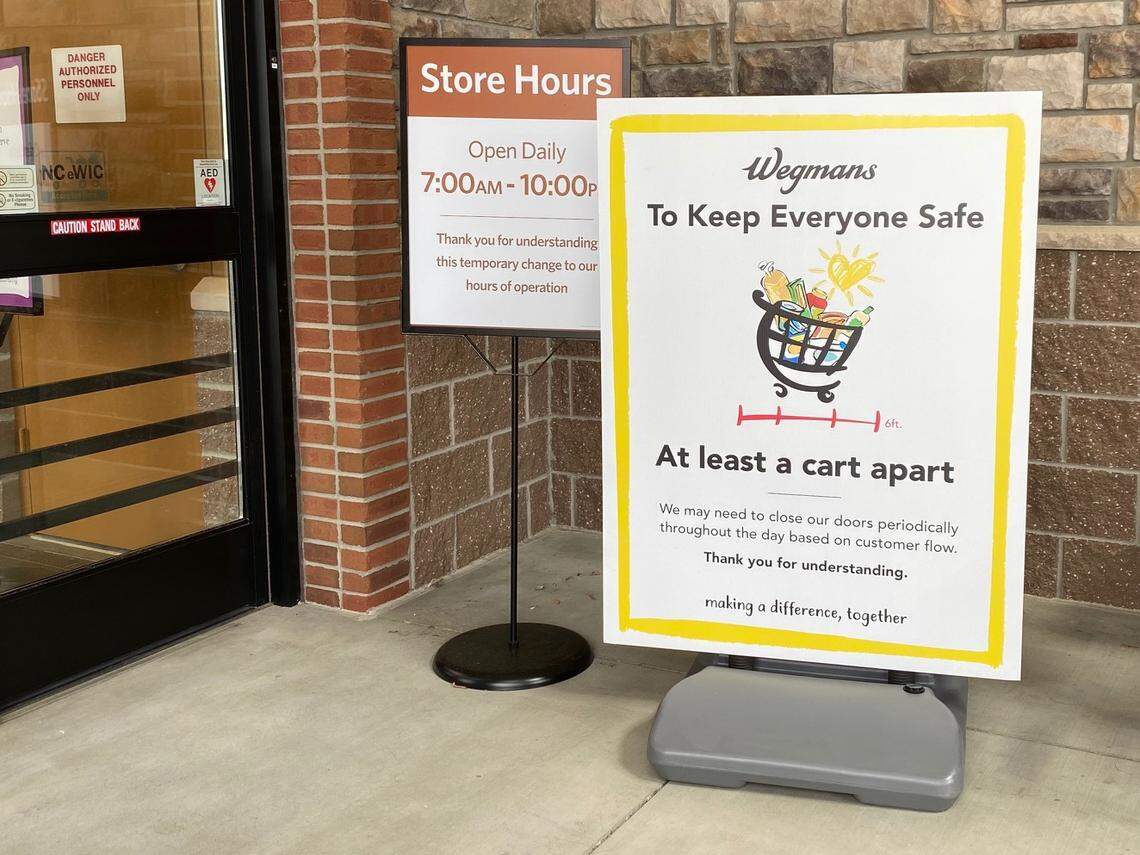 A sign at the entrance of the Wegmans grocery store in Raleigh reminds shoppers about the recommended 6-foot social distancing practice in an effort to stop the spread of COVID-19 coronavirus.