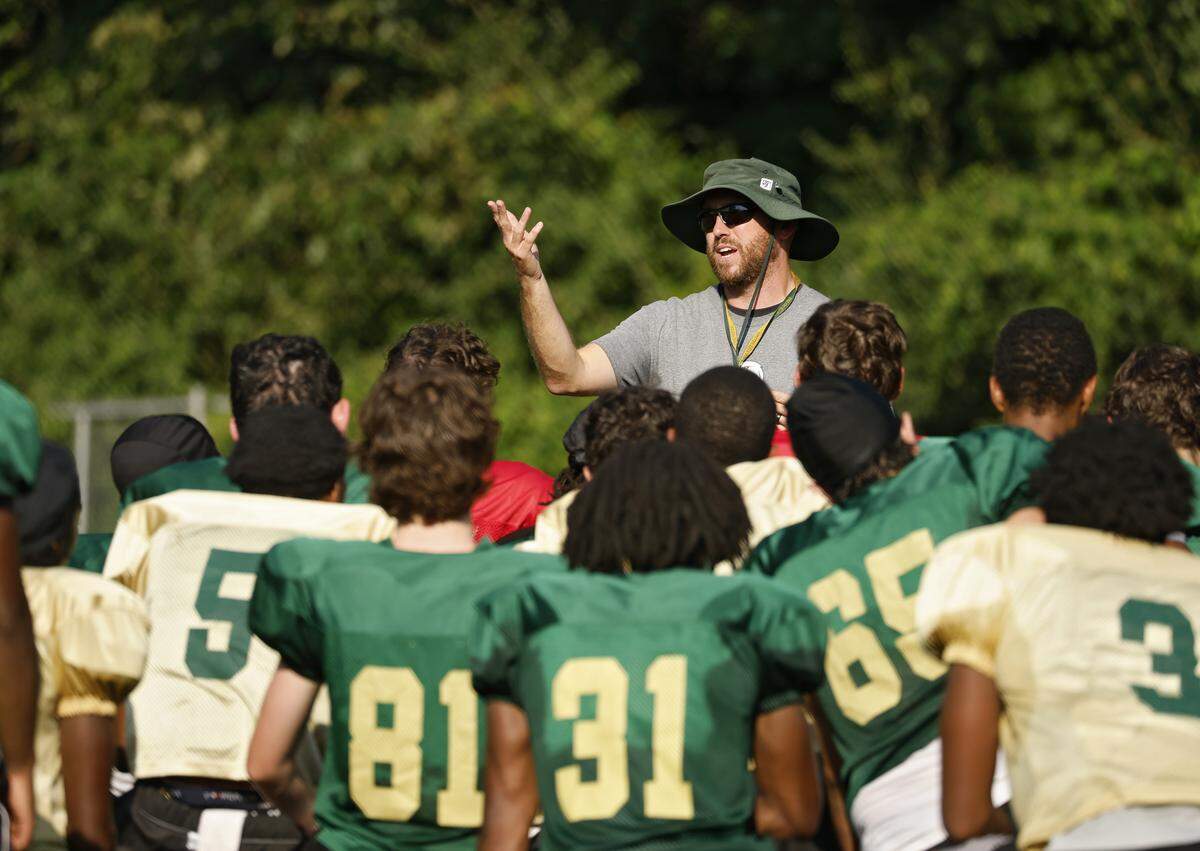 Enloe High School football coach Ryan Clark talks with his team following practice on Monday, Aug. 18, 2025, in Raleigh, N.C.
