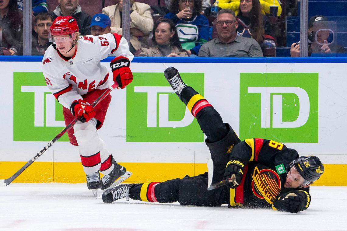 Oct 28, 2024; Vancouver, British Columbia, CAN; Carolina Hurricanes forward Jackson Blake (53) checks Vancouver Canucks defenseman Erik Brannstrom (26) during the third period at Rogers Arena. Mandatory Credit: Bob Frid-Imagn Images