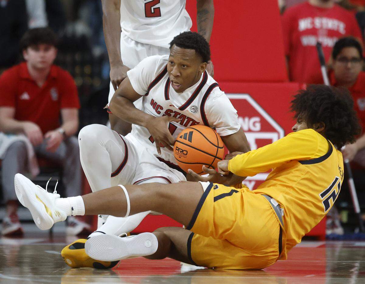 N.C. State’s Darrion Williams wrestles the ball away from UNC Greensboro’s Justin Neely during the first half of the Wolfpack’s 110-64 win on Wednesday, Nov. 12, 2025, at Lenovo Center in Raleigh, N.C.