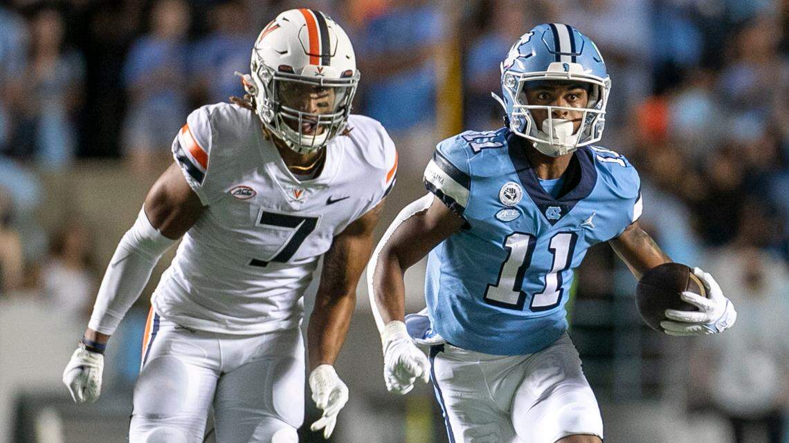 North Carolina’s Josh Downs (11) breaks away from Virginia’s Noah Taylor (7) on a 59-yard romp after a pass from quarterback Sam Howell in the first quarter on Saturday, September 18, 2021 at Kenan Stadium in Chapel Hill, N.C.