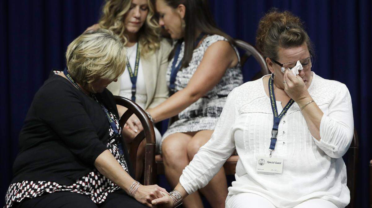Victims of clergy sexual abuse, or their family members react as Pennsylvania Attorney General Josh Shapiro speaks during a news conference at the Pennsylvania Capitol in Harrisburg, Pa., Tuesday, Aug. 14, 2018. A Pennsylvania grand jury says its investigation of clergy sexual abuse identified more than 1,000 child victims. The grand jury report released Tuesday says that number comes from records in six Roman Catholic dioceses.