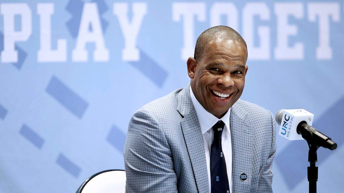 Hubert Davis flashes a smile as he fields questions from reporters after he was introduced at the new head basketball coach a the University of North Carolina on Tuesday, April 6, 2021 at the Smith Center in Chapel Hill, N.C. Davis a former North Carolina player and an assistant coach for Roy Williams, replaces Williams who retired last week following 18 years as head coach.