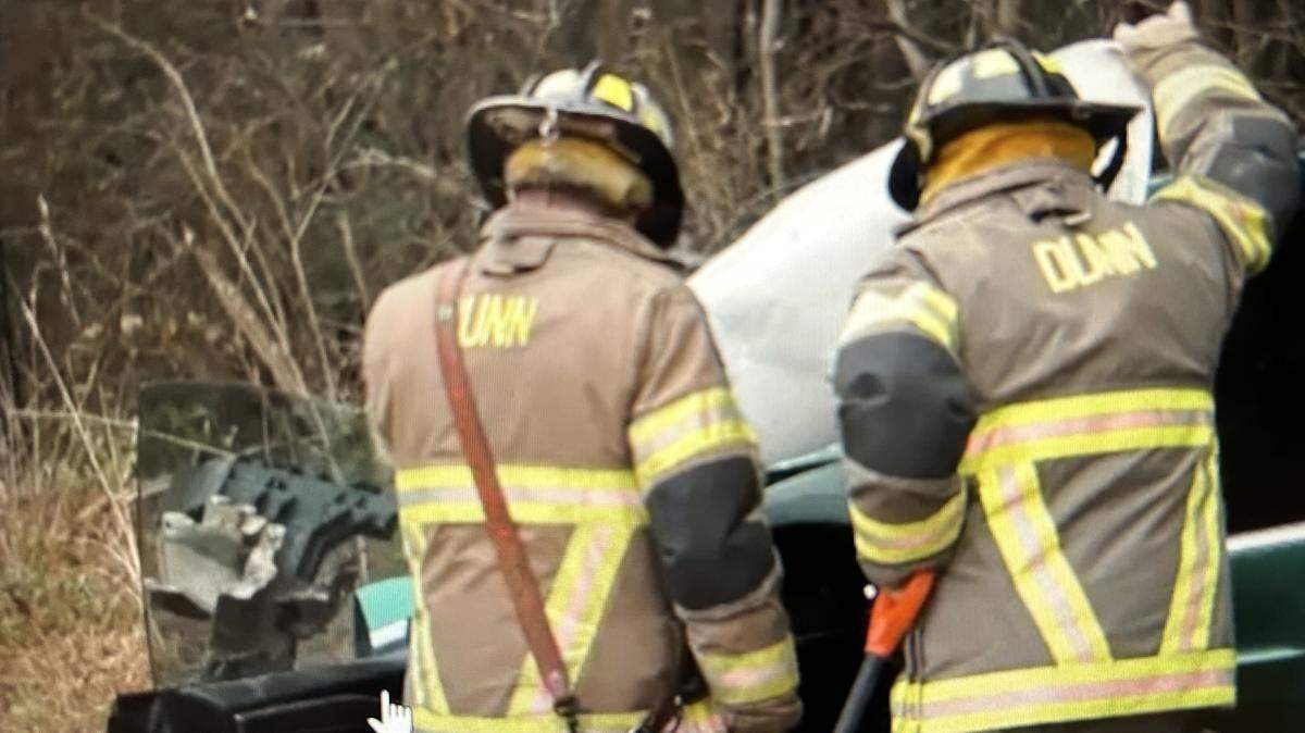 Firefighters in Harnett County work the accident scene near Benson where a Tesla crossed the center line and collided head-on with a pickup.