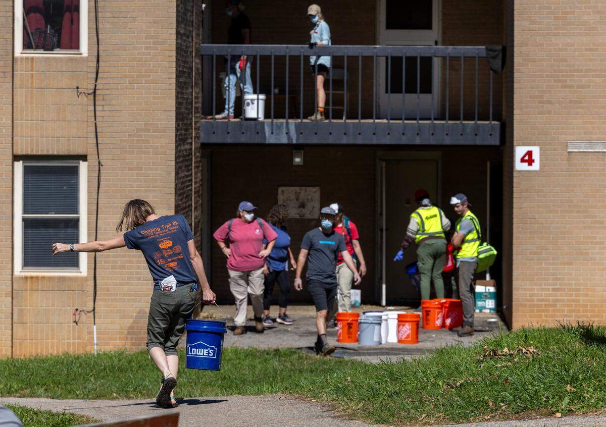 Volunteers organized by grassroots group BeLoved Asheville haul gray water to help residents in low-income independent living facilities, with no running water, flush their toilets on Wednesday, Oct. 9, 2024. About half of Asheville’s water customers were still without running water this week because the remnants of Hurricane Helene ripped apart the city’s distribution system.