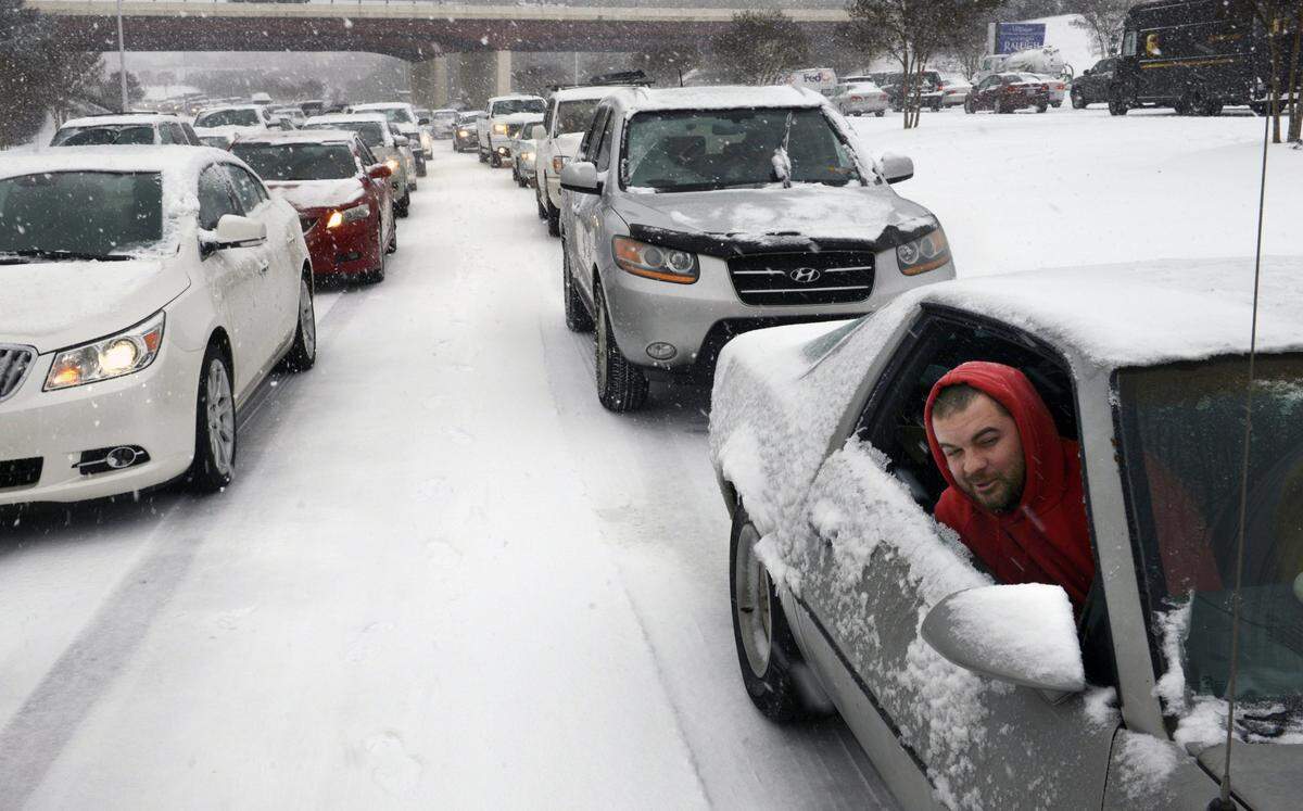 Kevin Miller looks out of the passenger window of his friend’s car as they sit in stuck traffic Wednesday afternoon Feb. 12, 2014, after snow and ice caused massive traffic jams in Raleigh.