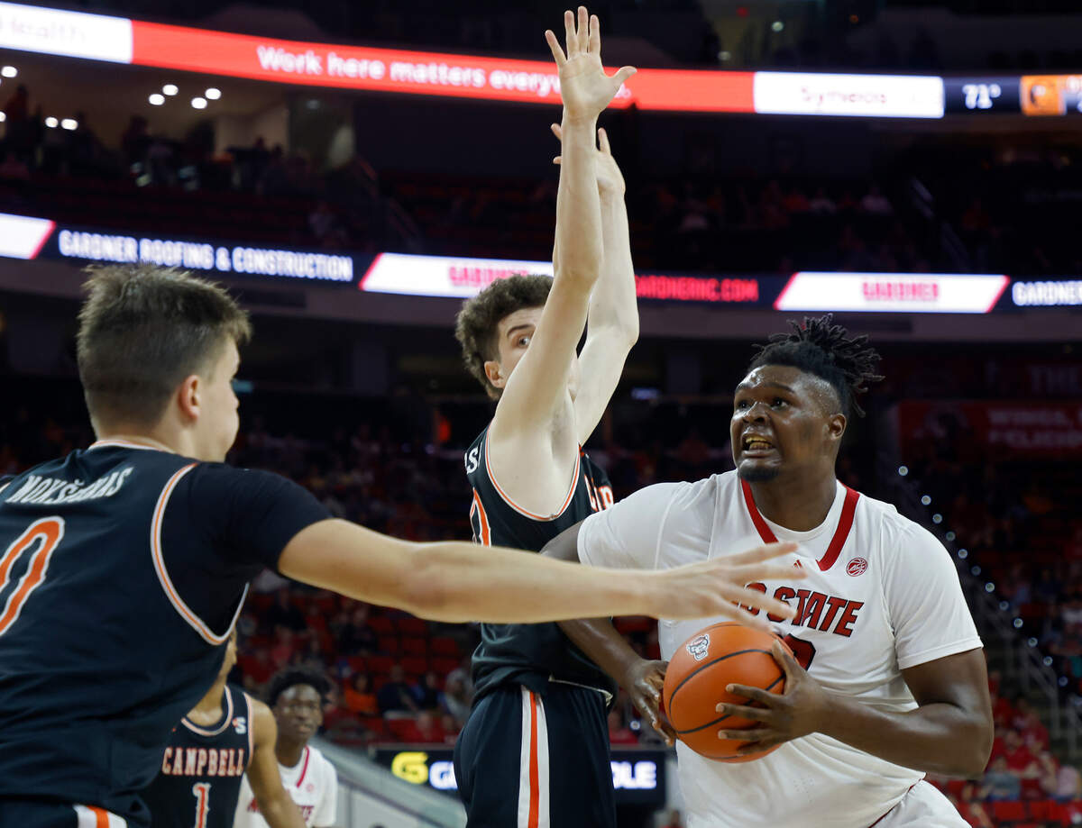 North Carolina State Wolfpack forward D.J. Burns Jr. drives by Campbell Fighting Camels guard Anthony Dell’Orso during the second half of a men’s basketball game at PNC Arena in Raleigh, N.C. on Friday, Nov. 11, 2022.