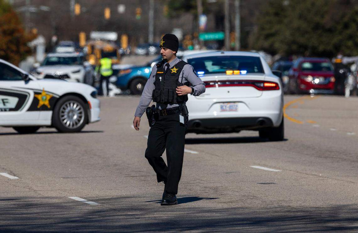 A Wake County Sheriff’s Deputy walks across Six Forks Road after the street was closed due to a shooting at N. Hills on Friday, January 17, 2025 in Raleigh, N.C.