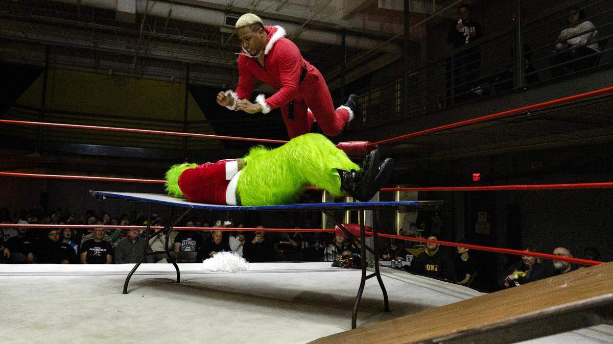 Santa, having lost his hair and beard earlier in the match, flys through the air from the top rope to lay out The Grinch and win the match at FWE Merry Mayhem in Cary, N.C., Saturday night, Dec. 14, 2024.
