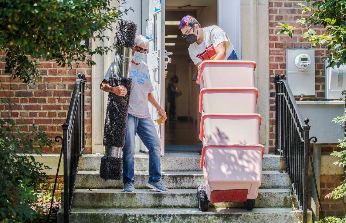 Lisa Denning, left, and Bryson Bridges, right, move items into Everett Residence Hall at UNC-Chapel Hill on Thursday, Aug. 12, 2021.
