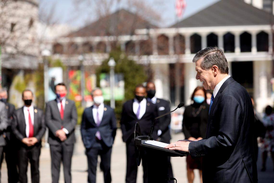 North Carolina Democratic Gov. Roy Cooper, right, and lawmakers gather Wednesday morning, March 10, 2021, for a press conference to announce that leaders of the Republican-led state legislature and the governor have reached an agreement to reopen the state’s K-12 public schools to full-time daily instruction.