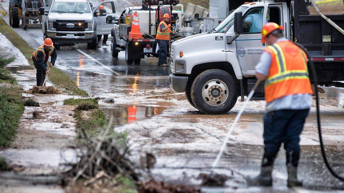 Orange Water and Sewer Authority employees clean up a section of Jones Ferry road in front of the Water Treatment Plant where a major water main break occurred on Monday morning.