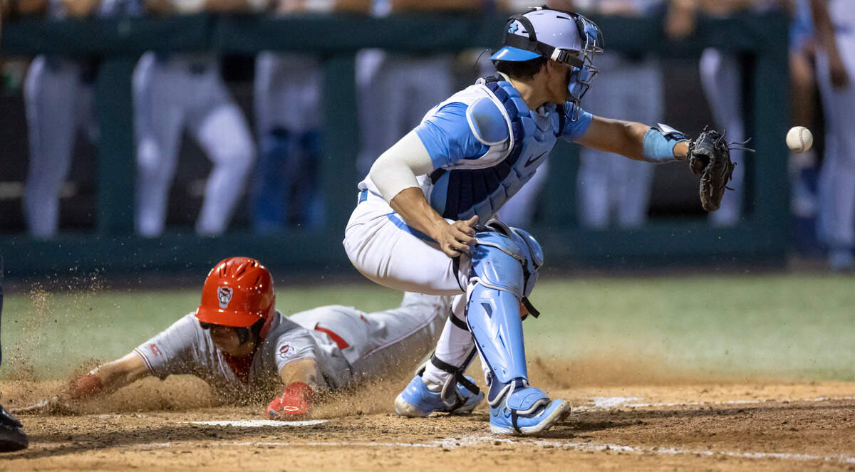 N.C. State’s Ty Head (14) scores ahead of the throw to North Carolina catcher Luke Stevenson (44) on a single to right field by Matt Heavner to give the Wolfpack a 5-3 lead against North Carolina in the top of the eighth inning on Friday, May 9, 2025 at Boshamer Stadium in Chapel Hill, N.C.