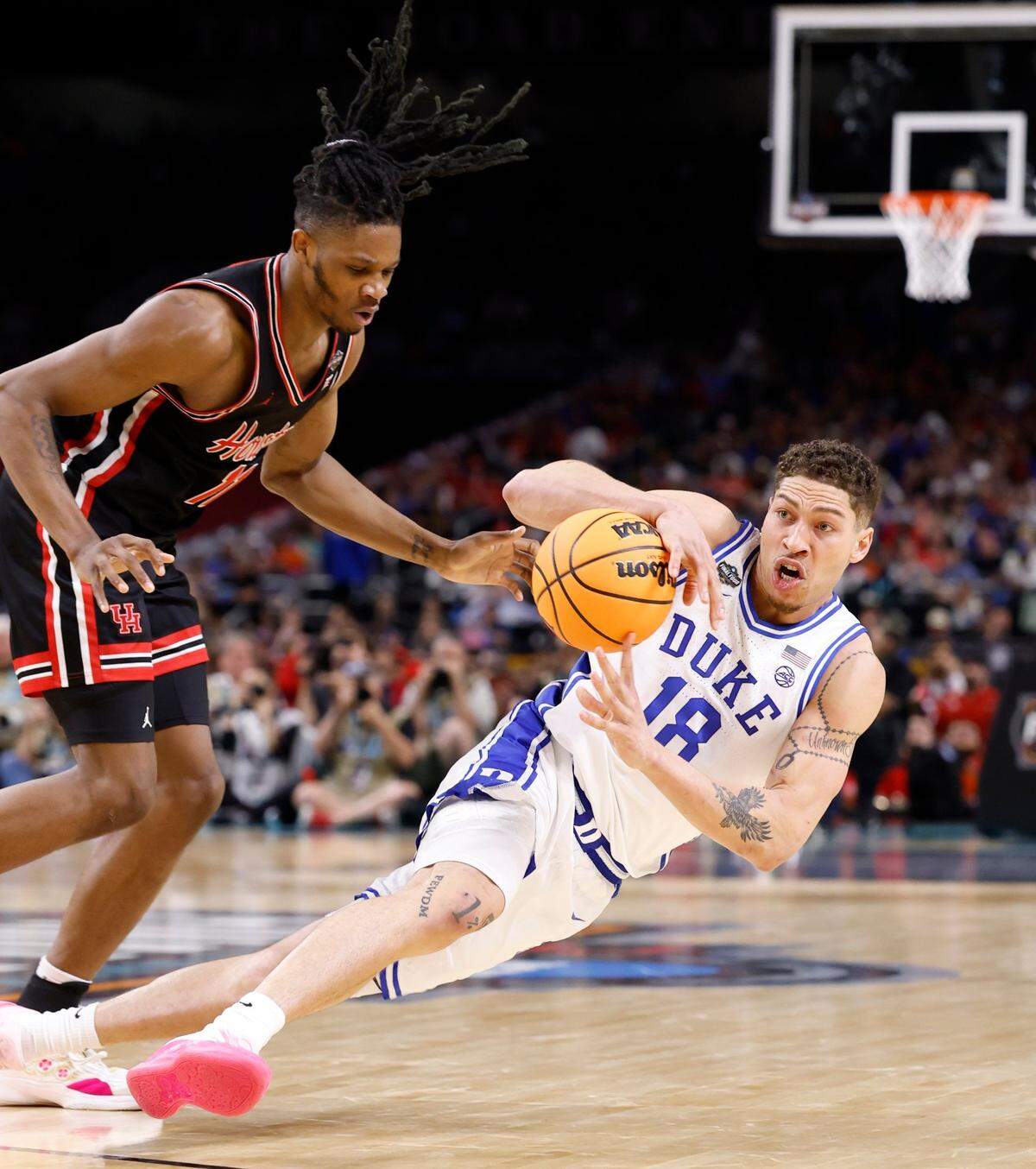 Duke’s Mason Gillis (18) falls to the floor after being fouled by Houston’s Joseph Tugler (11) during the first half of Duke’s game against Houston in the NCAA men’s national semifinal at the Alamodome in San Antonio, Texas, Saturday, April 5, 2025.