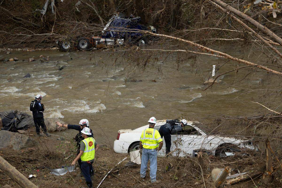 A FEMA search and rescue team from Maryland search for human remains in car in Swannanoa on Sunday, Oct. 6, 2024 after Tropical Storm Helene flooded the Swannanoa River. North Carolina officials have confirmed 76 deaths from Tropical Storm Helene.
